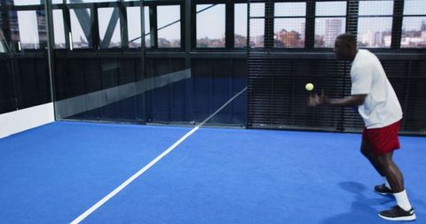 Athletic man adjusting vital skills on modern blue court