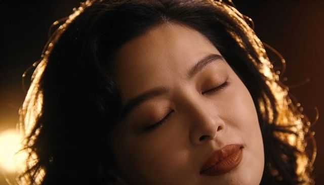 Serene asian woman with closed eyes in warm backlight rim lighting cinematic beauty portrait