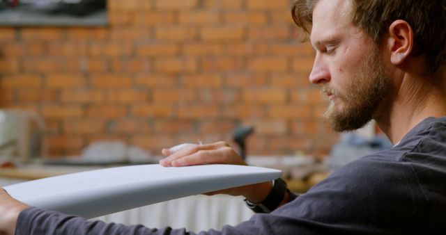 Dedicated Craftsperson Examining Surfboard in Workshop - Download Free Stock Images Pikwizard.com