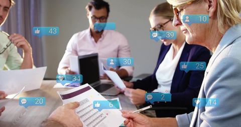 Senior woman executive reviewing reports with team while social engagement notifications overlay mee