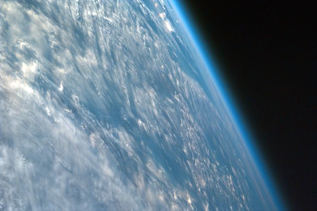 Showing the Earth’s atmosphere and cloud formations as seen from outer space. This view highlights the planet’s curvature and the thin blue layer of the atmosphere enveloping Earth. Ideal for educational materials, astronomy presentations, and environmental awareness campaigns.