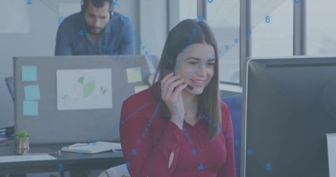 Female customer support representative using headset while working at modern office desk