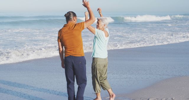 Happy senior caucasian couple dancing on beach. Senior lifestyle, realxation, nature, free time and vacation.