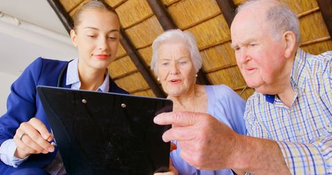 Seniors Discussing Health Plan with Female Doctor in Home Visit