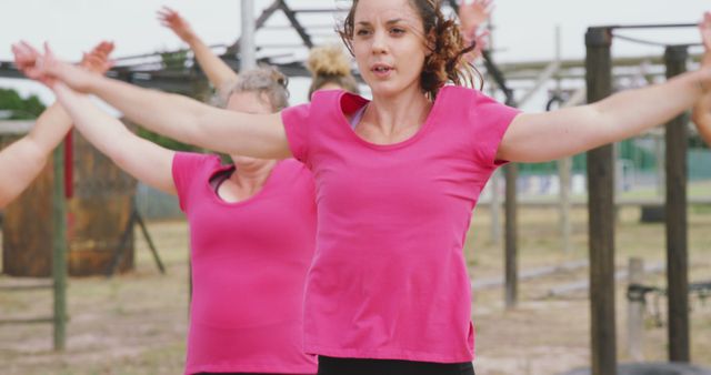 Women are engaged in an outdoor fitness bootcamp, performing exercises in an open outdoor environment. Suitable for promoting fitness classes, highlighting teamwork in physical exercise, and advertising sportswear or health and wellness programs.