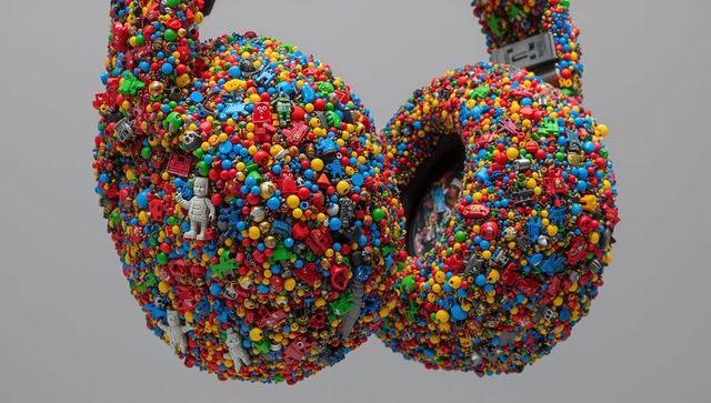 Upcycled over-ear headphones sculpture featuring colorful toy robots, beads, studs
