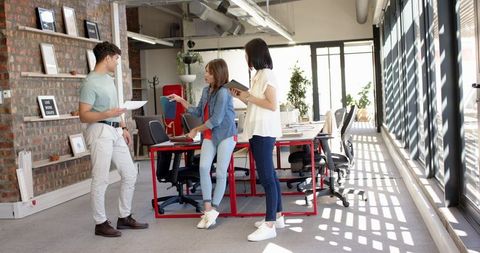 Coworkers collaborating in modern open-plan office