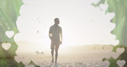 Man Walking on Beach at Sunset Surrounded by Heart Silhouettes