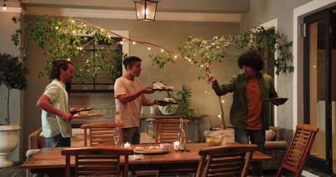 Friends Clearing Table After Celebration Dinner