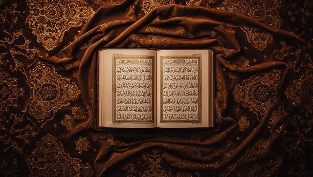 Resting open quran on gilded brocade showing arabic calligraphy and gold embroidery