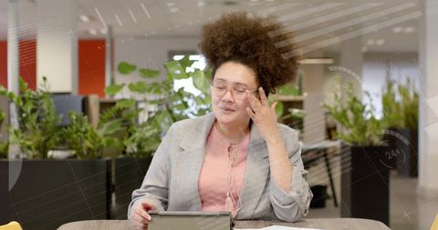 Businesswoman Using Tablet with Data Animation Overlay in Office