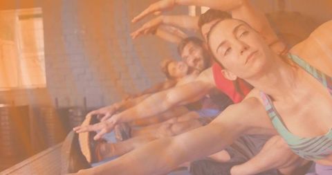 Mixed group stretching in sunlit yoga studio reaching overhead during mat workout session