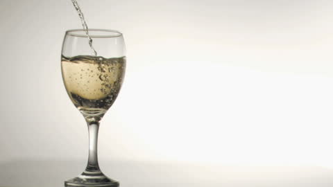 White Wine Pouring in Slow Motion Against Minimalistic Background