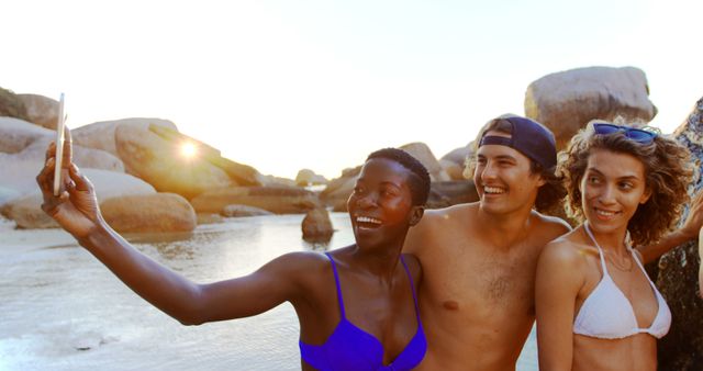 Smiling friends taking selfie on beach during sunset - Download Free Stock Images Pikwizard.com