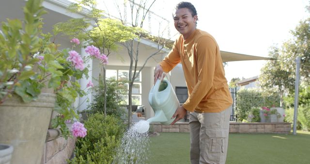 Smiling Man Watering Plants in Backyard Garden - Download Free Stock Images Pikwizard.com