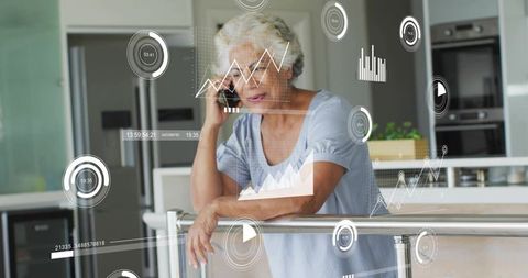 Senior woman leaning on counter using smartphone viewing augmented reality data overlays