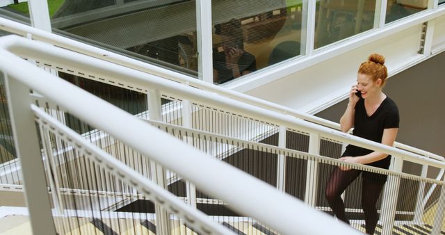 Businesswoman Talking on Phone While Climbing Stairs in Modern Office - Download Free Stock Images Pikwizard.com