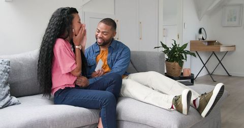 Excited couple reacting to positive pregnancy news at home