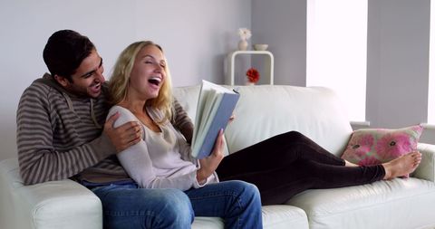 Happy Couple Enjoying Time Together Reading on Couch - Download Free Stock Images Pikwizard.com
