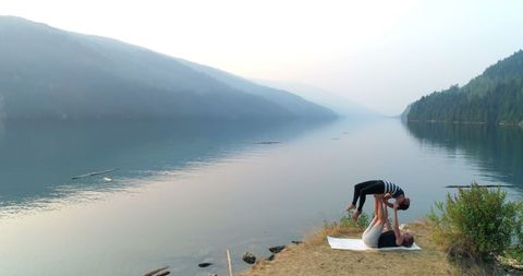 Tranquil Yoga Balance Near Serene Lakeside and Mountains