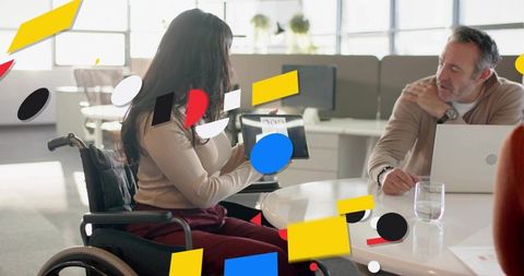 Businesswoman in wheelchair presenting tablet during inclusive team meeting in office
