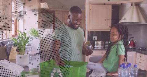 Smiling father and daughter sorting recyclable items in kitchen