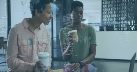 Tech coworkers collaborating on code at modern office lounge