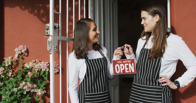 Two Female Small Business Owners Holding Open Sign Outside Store Entrance - Download Free Stock Images Pikwizard.com