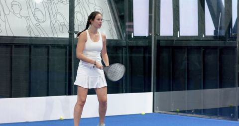 Female Padel Player Focused on Court Ready to Serve