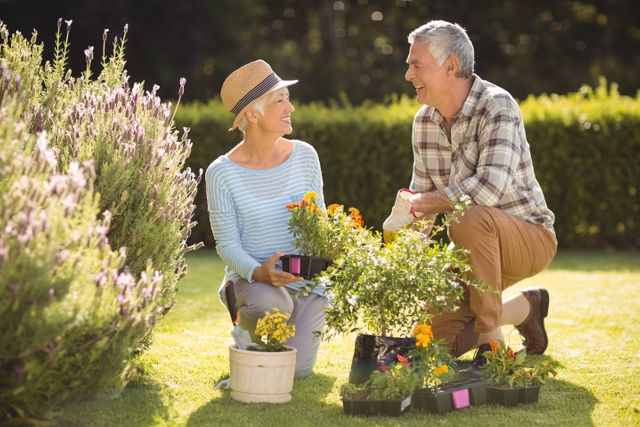 Portrait of happy senior couple gardening together in backyard