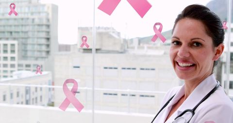 Smiling Female Doctor Supporting Breast Cancer Awareness with Pink Ribbons