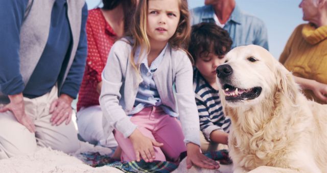 Family enjoying time together at beach with their golden retriever. Children playing in sand while adults smile and relax. Ideal for promoting family vacations, outdoor activities, pet companionship, and summertime fun.