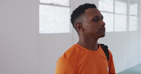 Man in Orange Shirt Contemplating Indoors - Download Free Stock Images Pikwizard.com