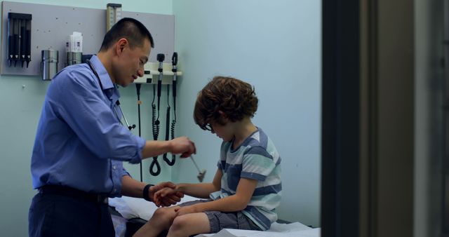 Pediatric doctor examining a young boy in a clinical setting. The doctor is using medical equipment to diagnose the child's condition. Image is suitable for illustrating pediatric healthcare, medical consultations, children's health, and doctor-patient interactions in articles, advertisements, and educational materials.