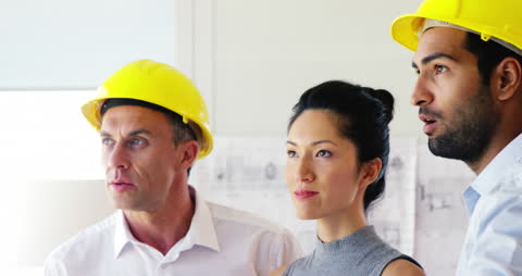 Architect Team Discussing Blueprint Ideas at Modern Office