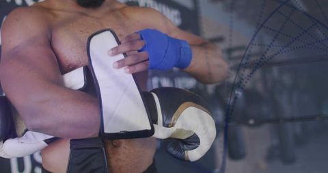 Boxer Wrapping Hands and Holding Gloves in Gym Setting