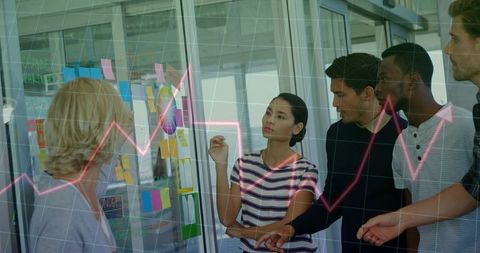 Team collaborating at glass board with sticky notes and rising magenta chart overlay
