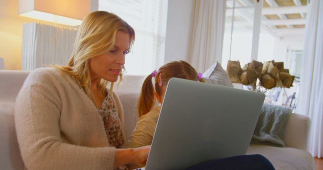 Mother and Daughter Using Laptop Together on Sofa at Home - Download Free Stock Images Pikwizard.com