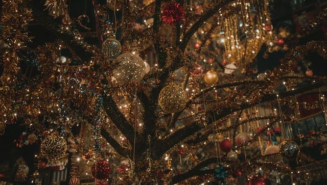 Luxurious holiday ornaments on tinsel-adorned branch