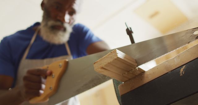 Carpenter Cutting Wood Piece with Handsaw in Workshop - Download Free Stock Images Pikwizard.com