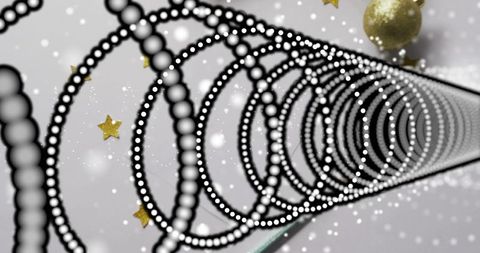 Spiraling beaded black ring helix with white dots and gold stars creating abstract depth