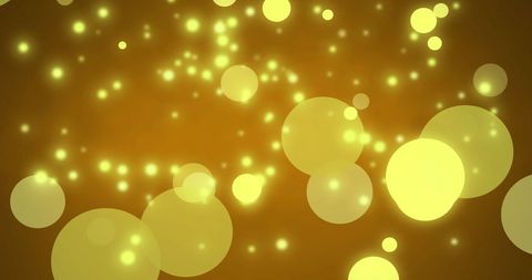 Luminous yellow bokeh lights overlay on warm tone background