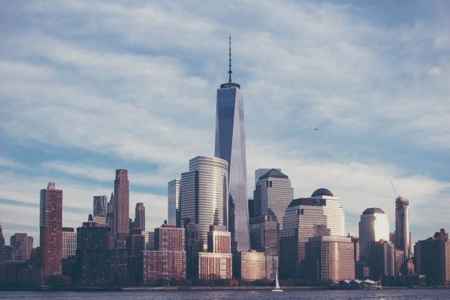 View of New York City's iconic skyline, featuring modern skyscrapers with One World Trade Center prominently in the center. Ideal for use in travel brochures, city guides, architectural studies, urban development promotions, real estate advertisements, and tourism materials showcasing New York City's dynamic cityscape.