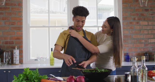 Happy couple cooking together in modern kitchen with vegetables on counter - Download Free Stock Images Pikwizard.com