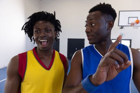 Energetic African American Friends Sharing Laughs on Basketball Court