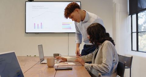Diverse Professionals Analyzing Data in Modern Office Meeting