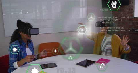 Women using vr headsets with holographic icons in modern office