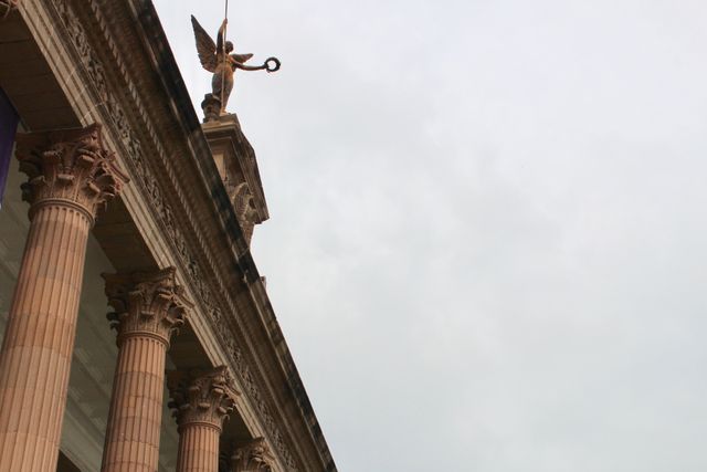 This image showcases an ornate historic building featuring Corinthian columns and an equestrian statue dominating its facade. Perfect for use in travel blogs, historical articles, cultural site promotions, or educational material related to architecture and classical structures.