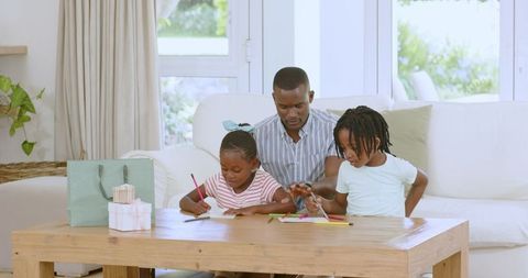 Father and Children Engaging in Creative Activity with Colored Pencils at Home