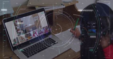 Remote classroom learning at home: child wearing headphones writing while attending virtual class